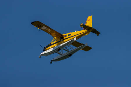 Yellow floatplane flying over Algonquin Provincial Park
