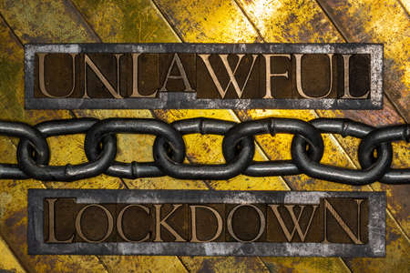 Unlawful Lockdown text formed by real authentic typeset letters with steel chain on vintage textured...