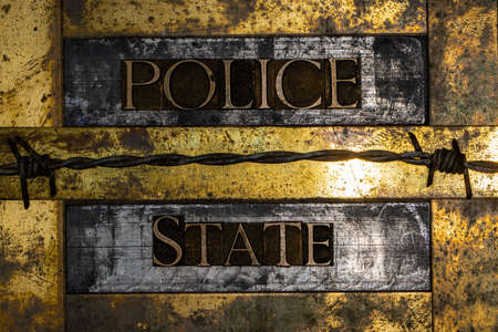 Police State text message on vintage textured grunge copper and gold background with barbed wireの写真素材