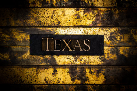 Texas text on sand colored grunge textured copper and gold backgroundの写真素材