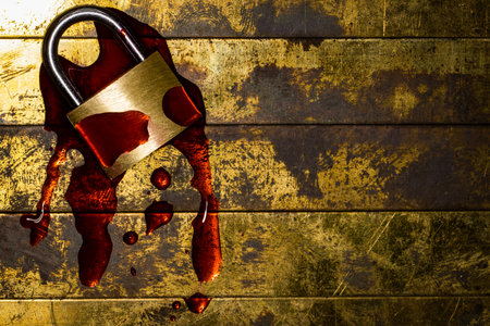 Bleeding lockdown padlock on grunge textured copper and gold background with copy space symbolizing mental and economic damageの写真素材