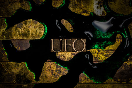 UFO text over green fluid on textured grunge copper backgroundの写真素材