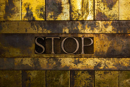Stop text on textured grunge copper and vintage gold background.の写真素材
