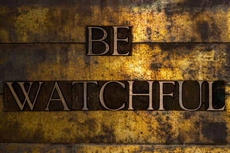Be Watchful text on textured grunge copper and vintage gold backgroundの写真素材
