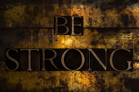Be Strong text on textured grunge copper and vintage gold backgroundの写真素材