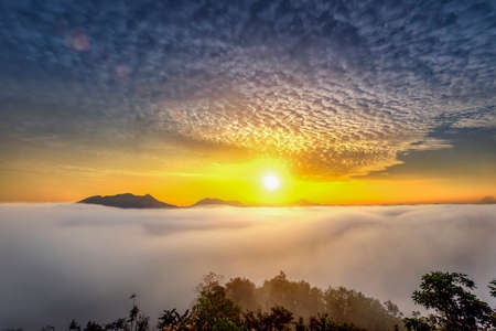 The scenery view of the sunrise and mist fog flowing in between the hills mountain, nature morning in the wildlifeの写真素材