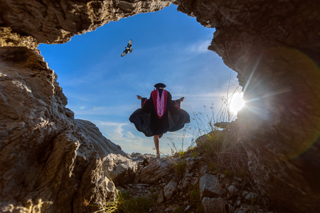 women college celebration of her graduate at the blue sky in view from the cave