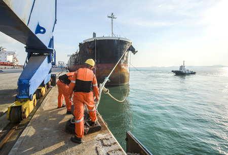 mooring gangs attending to un-berth the ship on sailing departure from the terminal of portの写真素材