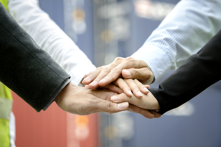 Teamwork concept, Business team standing hands together in the containers yard, people joining for cooperation success business,win in every thingの写真素材