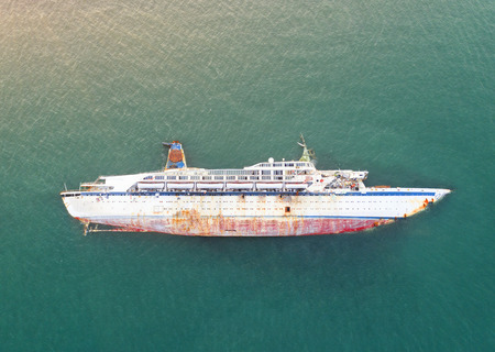 disaster of the passenger vessel capsize and sunk into the sea ocean at sunset in aerial view