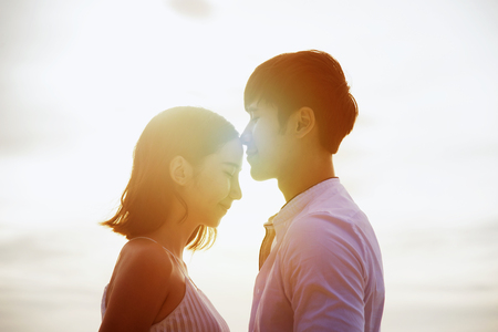Couple lover kiss on forehead of woman at light of sunset in background at anniversary of honeymoon and valentine occasionの写真素材
