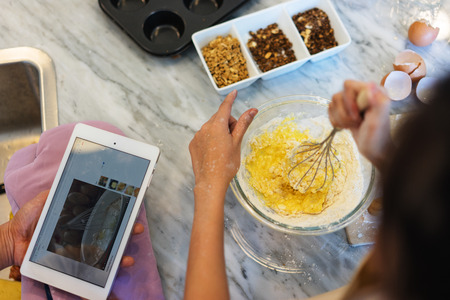couple lover help o each other cooking online, learning cooking from website internet for a new...