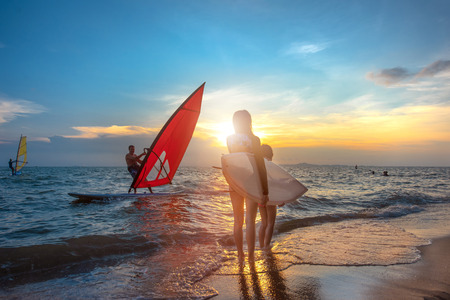 Slim woman with family group father, sister are enjoy around with water sports such surfboard,...