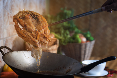 local asian drip fish red snapper fully fried in pan style asianの写真素材