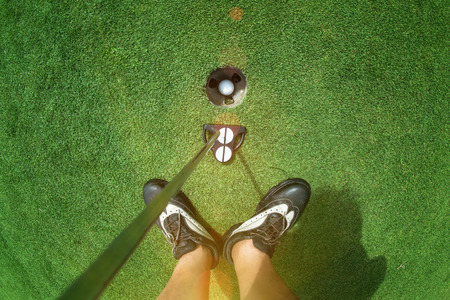 legs of glof player with butter standing on the green after putted a golf ball completed to the hole on the green, Successfully and cheerfully enjoy of the winner challengeの写真素材