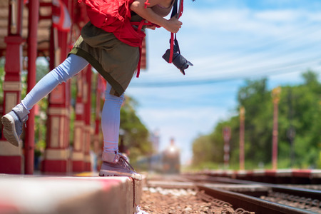 tourist woman walking step lean out of railway station and looks at the incoming train for destination trip, holidays and weekend vacation travelingの写真素材