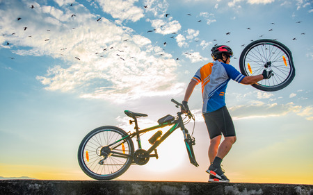 man bicycle cyclist in trouble of front tire wheel on accident clashed, needs repair and by workshop, drag and pull bicycle away with mind upsetの写真素材