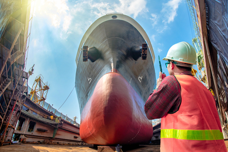 inspector, surveyor, port control or engineering and supervisor in review of the condition of the commercial ship bulk head after repainting recondition in dry dock yard, report, onlineの写真素材