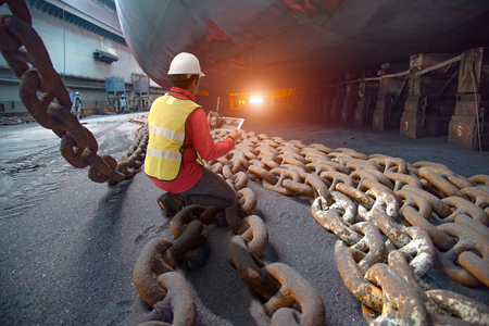 Stevedore, port controller, Port Master, surveyor inspect under bottom hull chains bundle of...