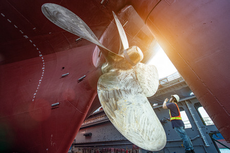 Stevedore, controller, Port Master, surveyor inspect theaft stern propeller of the ship in floating dry dock, recondition of overhaul repairing and painting, sand blasting in dry dock yardの写真素材