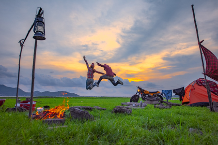 couple lover enjoy camping in jumping freedom, countryside traveling of the couple lover, campfire enjoyingの写真素材