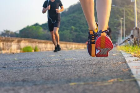 leg of heathy woman running jog in road progress to destination ahead, trail running of the woman...