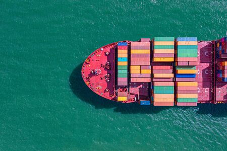 top aerial view of the large volume of TEU containers on ship sailing in the sea carriage the...