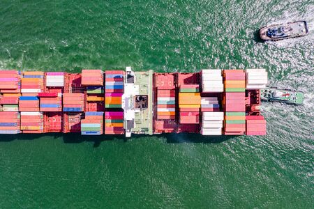 top aerial view of the large volume of TEU containers on ship sailing in the sea carriage the...