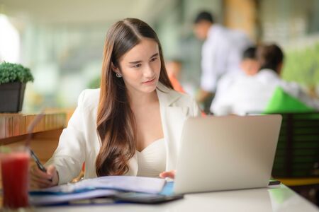 freelance working woman in busy of business, working outdoor online anytime and anywhere to reach customer satisfyの写真素材