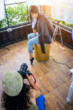 woman freelance photographer and blogger working individual at own office studio with acting model...