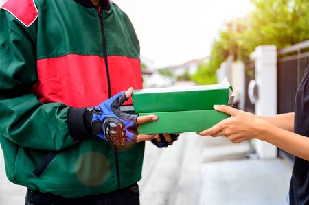 pizza boxes case being delivery to the customer services from door to door at swift services, hand of pizza man and house keeper holding pizza boxes oderingの写真素材