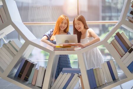 young asian student enjoy reading book together in library of University