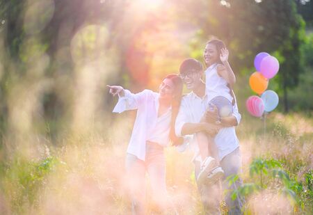 group of warm family enjoy playing together in wildflowers meadow field at light of morning sunriseの写真素材