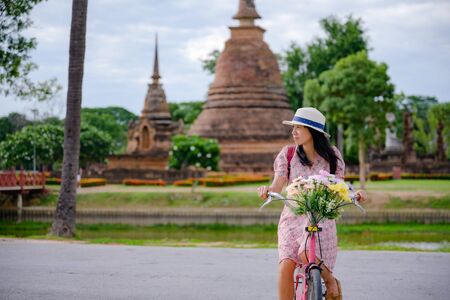 woman tourist enjoy riding local bicycle to see the historic park of Thailandの写真素材