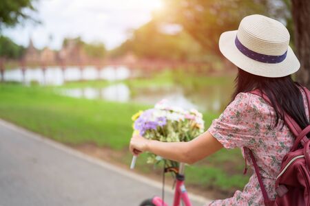 Woman riding old fashion bicycle in the antiquate park along the riverの写真素材
