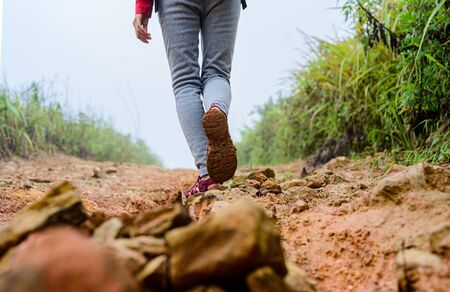 legs of traveller woman step on the way difficult of mud slop suffering to the blind destinationの写真素材