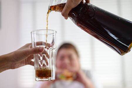 high calories beverage drink serving for plump fatty woman hunger eating a lot junk food in...