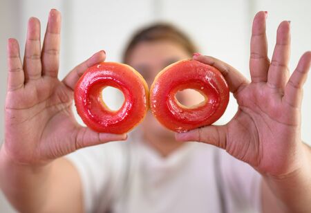hand of fatty hunger woman eating a lot of junk food sweet donut with high calories creamy