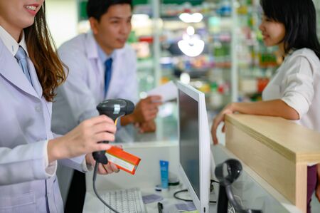 pharmacist in charge paying of medicine cost at pharmacy counterの写真素材
