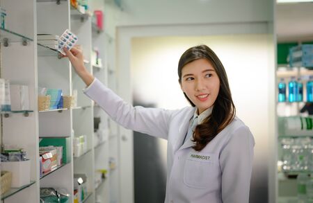woman pharmacist holding box or case of medicine container, selling medicine under official authorizationの写真素材