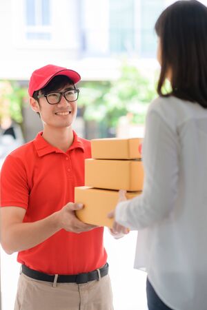 delivery man attending to delivery parcel packages to destination end, handover parcel packages from delivery man to customerの写真素材