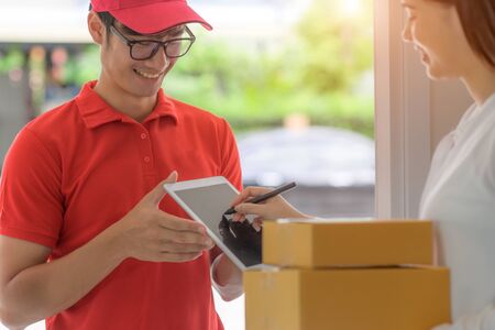 delivery boy in charge of sending packages parcel to customer, device signed received report online to completed parcel deliveredの写真素材