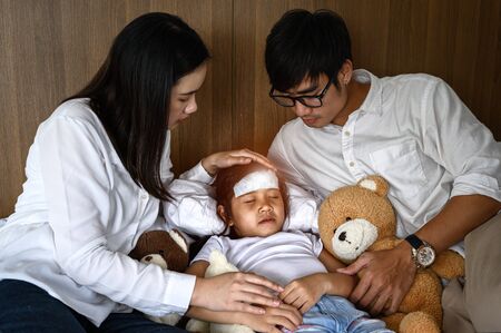 family takes care of member sick in bedroom, worry and keep close looking for effective futureの写真素材