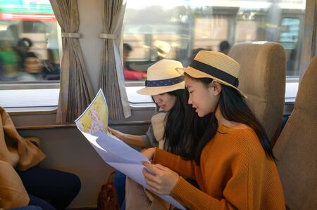 Women Traveller in transport on train looking in ordinary map for properly destination, travel on public transport by owns way selectionの写真素材