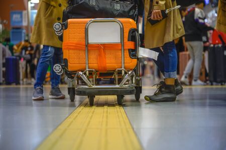 Many luggages carry in trolley in airport by woman traveller, busy in transports carry out of travellers in the airportの写真素材