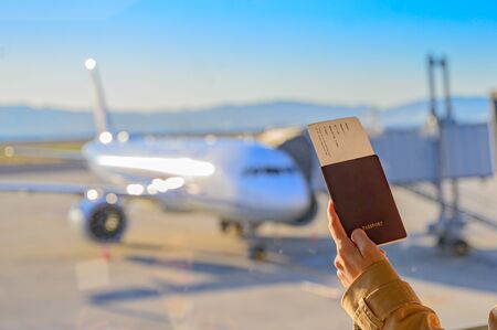 passport and boarding pass in hand of passenger woman stand by for boarding in counter gate,...