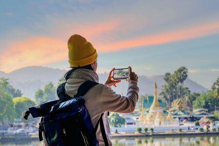 woman traveller enjoy taking photo on the terrace in the light of morning, Mae Hong son, wat Chong...