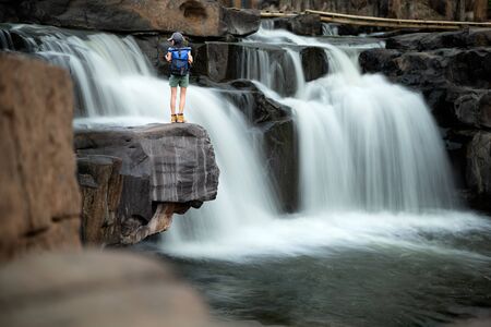 Woman traveller backpacker enjoy motion sightseeing to see jungle waterfalls in rainforest tropical at summertime and long weekend vacation trip, away from the place of crowdの写真素材