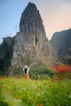 Woman in retro dress enjoy freedom walks in the flowers field meadow in Countryside, disconnected and away from the place of crowd, social distancing の写真素材