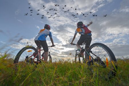 family couple lover enjoy the life of biking on the fresh field meadow grass, cheerfully life together outdoorsの写真素材